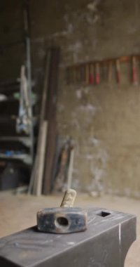 Metal atölyesindeki tezgahta çekicin dikey videosu. Demirci ocağında küçük bir işletme ve işçilik..