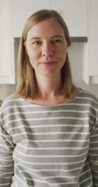 Evdeki mutlu beyaz kadın portresinin dikey videosu. Evde yalnız zaman geçirmek..