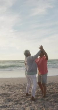 Sunny Beach 'te dans eden mutlu çiftlerin dikey videosu. sağlıklı, aktif emeklilik plaj tatili.