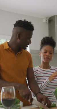 Afro-Amerikan çiftin evde yemek pişirdiği dikey video. Evde birlikte vakit geçirmek..