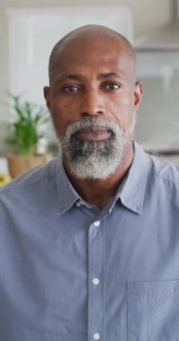 Kameraya bakan mutlu Afro-Amerikan bir adamın dikey videosu. Rahatlayın, rahatlayın, evde boş zaman geçirin..