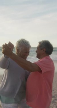 Sunny Beach 'te dans eden mutlu çiftlerin dikey videosu. sağlıklı, aktif emeklilik plaj tatili.