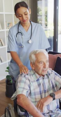 Üst düzey hastayla ilgilenen mutlu çift ırklı kadın doktorun dikey videosu. Yaşlılar sağlık ve huzurevi konsepti.