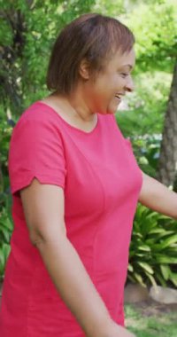 Afro-Amerikan büyükanne ve torununun kucaklaşmasının dikey videosu. Aile evde birlikte vakit geçiriyor..