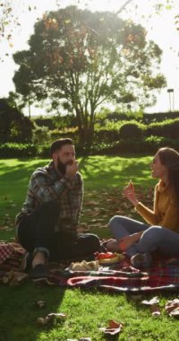 Sonbahar bahçesinde piknik yapan mutlu çiftin dikey videosu. Yaşam tarzı, aşk, ilişki ve birlikte zaman geçirme kavramı..