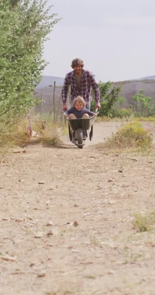 笑顔の白人の父親の垂直ビデオ車列で田舎の車線を押し下げる 有機農場での身体的包容力 ホームステージング 健康的な家庭生活 — ストック動画