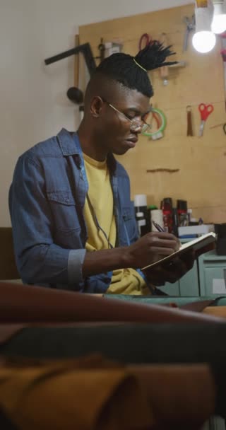 Vertikální Video Afrického Amerického Řemeslníka Dredy Jak Píše Poznámky Dílně — Stock video