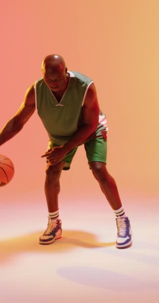 Vertikal Video Afrikansk Amerikansk Manliga Basketspelare Studsande Boll Orange Bakgrund — Stockvideo