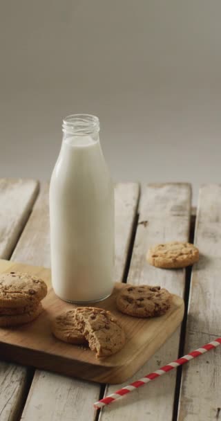 Video Verticale Biscotti Con Gocce Cioccolato Bicchiere Latte Tagliere Sfondo — Video Stock
