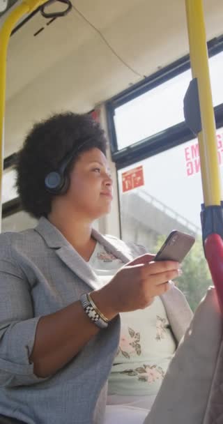 헤드폰을 버스에서 스마트폰을 사용하는 여성의 도시에서 심부름을 — 비디오
