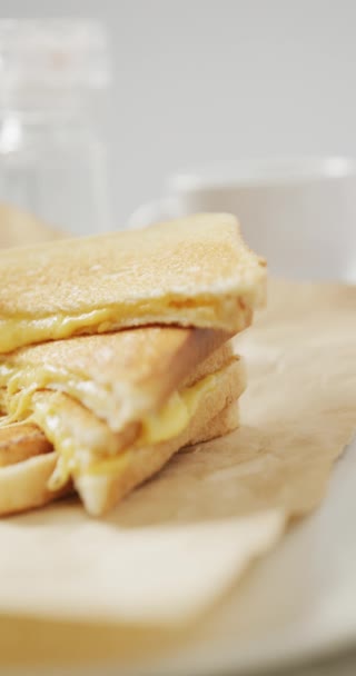 灰色の背景に溶かしたチーズと新鮮なトーストのクローズアップの垂直ビデオ 新鮮な自家製スナックや朝食 — ストック動画
