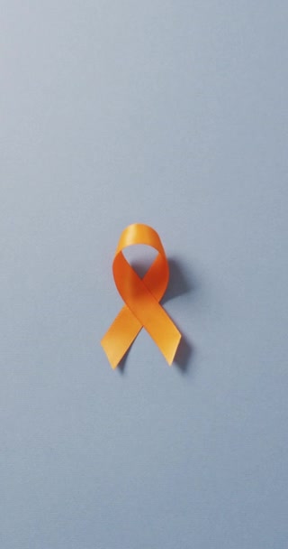 Κάθετο Βίντεο Από Πορτοκαλί Κορδέλα Μπλε Φόντο Υγεία Πρόληψη Ιατρική — Αρχείο Βίντεο