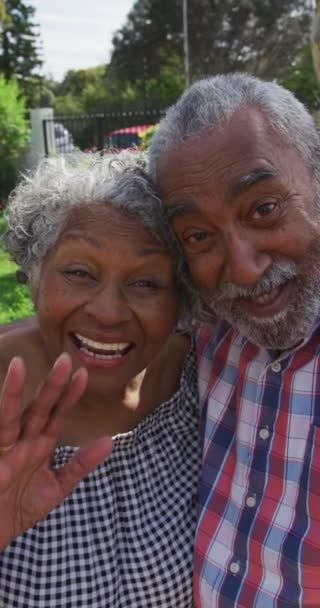 アフリカ系アメリカ人のカップルがビデオ通話をし 笑顔でカメラに手を振って垂直撮影しました 先輩と技術の概念 — ストック動画