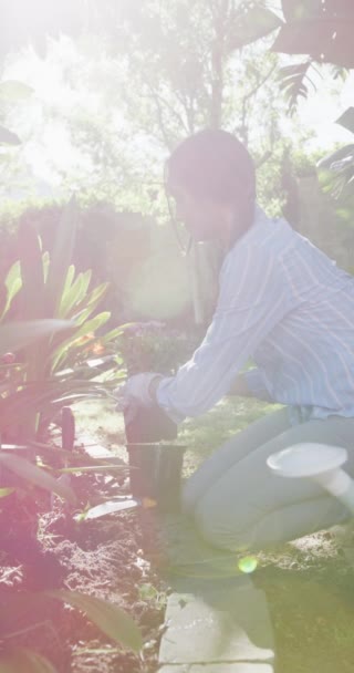 在阳光明媚的花园里种植花朵的快乐的鸟女人的垂直视频 家庭生活和包容性概念 — 图库视频影像