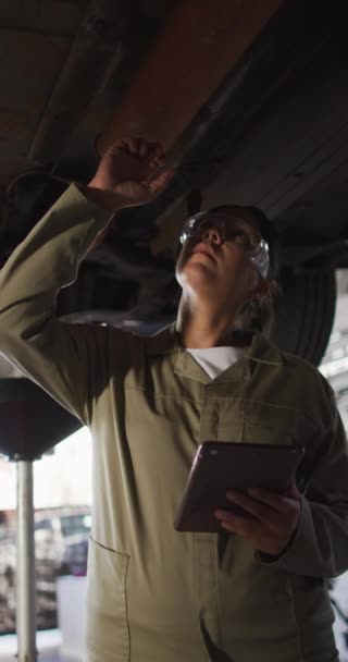 Vertical Video Biracial Female Car Mechanic Using Tablet Checking Car — Stock Video