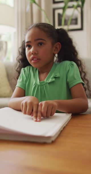 在家里 一个穿着绿色衣服的快乐的女孩在看布莱叶的垂直视频 残疾和在家里度过的时间 — 图库视频影像