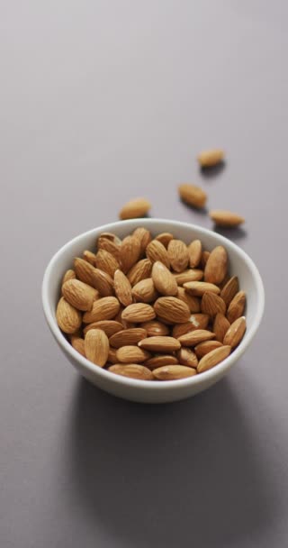 Video Vertikal Semangkuk Kacang Almond Dengan Latar Belakang Ungu Makanan — Stok Video