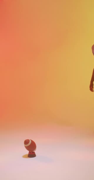 ネオンオレンジの照明とアフリカ系アメリカ人男性アメリカ人サッカー選手の垂直ビデオ スポーツ トレーニング アクティブなライフスタイルの概念 — ストック動画