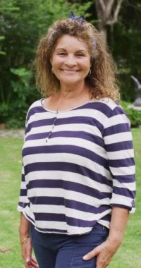 Bahçedeki mutlu beyaz kadın portresinin dikey videosu. Aile evde birlikte vakit geçiriyor..