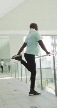 Kıdemli Amerikalı Afrikalı erkeklerin egzersiz yaptığı dikey bir video. Emeklilik yaşam tarzı, yalnız zaman geçirme, aktif boş zaman..