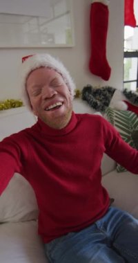 Kameraya gülümseyen, Noel Baba şapkası takan bir Albino 'nun görüntüsü. Noel konsepti.