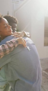 Afro-Amerikan çiftin evde kucaklaştığı dikey video. Evde birlikte vakit geçirmek..