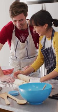 Mutlu çiftin un pişirip oynamasını gösteren dikey video. Aşk, ilişki ve birlikte kaliteli zaman geçirme kavramı.