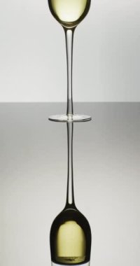 Beyaz arka planda beyaz şarap ya da şampanya kadehinin dikey videosu. Lüks, eğlence ve kutlama..