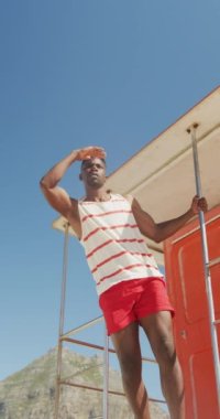 Uzaktaki mutlu Amerikan cankurtaranının dikey videosu. Tatiller, tatiller ve yaşam tarzı konsepti.