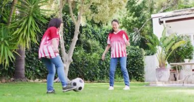 Mutlu Asyalı anne ve kızının bahçede futbol oynadığı bir video. Aile, annelik, ilişkiler ve birlikte kaliteli zaman geçirme konsepti dijital olarak oluşturulmuş video.