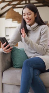 Akıllı telefon kullanan ve gülümseyen melez bir kadının dikey videosu