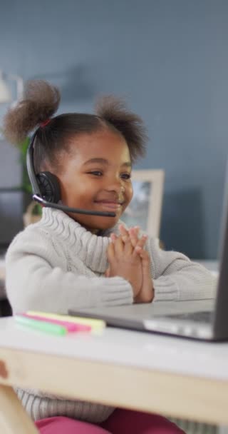ビデオ通話を持つ幸せなアフリカ系アメリカ人の少女の垂直ビデオ 家庭のコンセプトで質の高い時間を過ごす — ストック動画