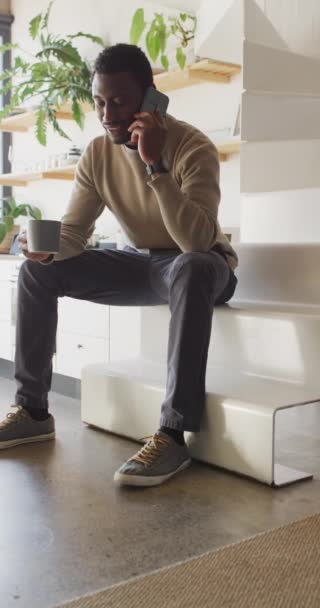 Vídeo Vertical Del Hombre Afroamericano Feliz Bebiendo Café Hablando Teléfono — Vídeos de Stock