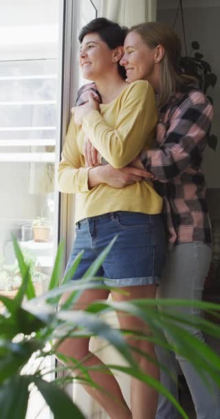 在家里拥抱快乐的高加索女同性恋夫妇的垂直视频 一起呆在家里 — 图库视频影像