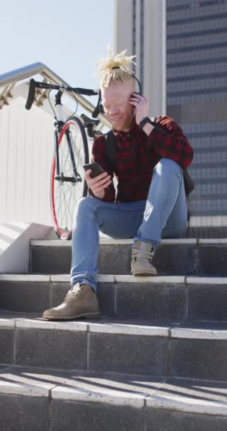 Κάθετη Βίντεο Του Ανθρώπου Albino Dreadlocks Χρησιμοποιώντας Smartphone Κάθεται Βήματα — Αρχείο Βίντεο