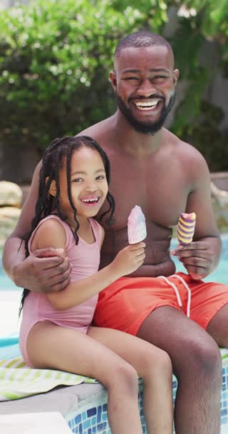 Videoclip Vertical Tată African Fericit Fiică Care Mănâncă Înghețată Piscină — Videoclip de stoc