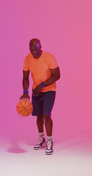 Verticale Video Van Afro Amerikaanse Mannelijke Basketbalspeler Stuiterende Bal Roze — Stockvideo