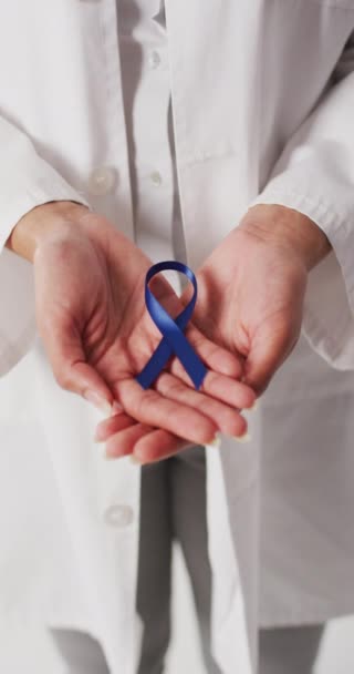 带着蓝色带子的鸟类女医生双手的垂直视频 预防和癌症意识概念 — 图库视频影像