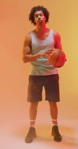 Вертикальне Відео Баскетболіста Ячем Помаранчевому Фоні Концепція Спорту Змагань — стокове відео