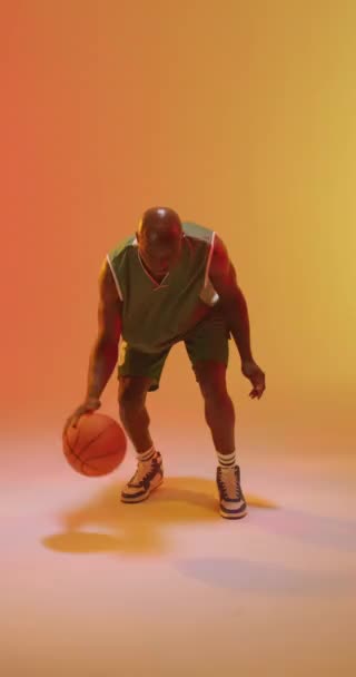 Вертикальне Відео Афроамериканського Баскетболіста Який Кидає Помаранчевому Тлі Спорт Конкуренція — стокове відео