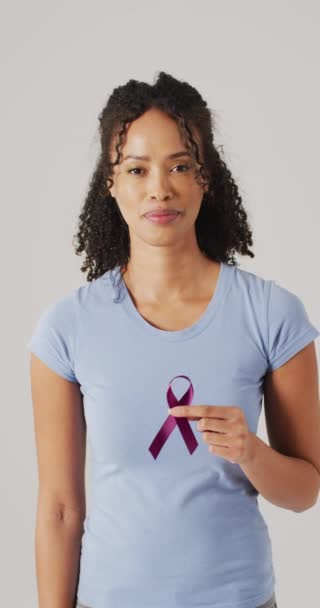 幸せな熟女が紫色のリボンを灰色の背景に持っている垂直ビデオ 健康医学予防癌意識の概念は — ストック動画