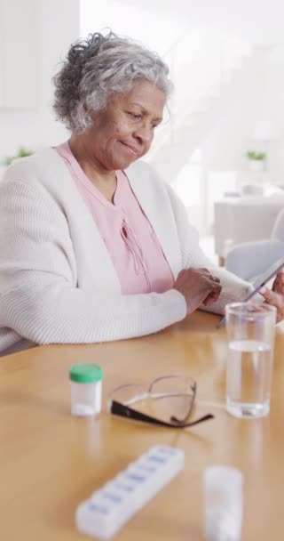 Вертикальное Видео Старшей Африканской Женщиной Сидящей Столом Принимающей Таблетки Выход — стоковое видео