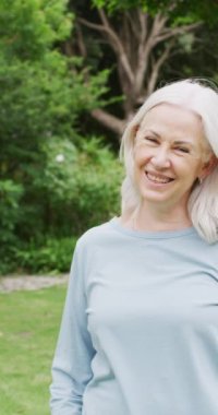 Bahçedeki mutlu beyaz kadın portresinin dikey videosu. Aile evde birlikte vakit geçiriyor..