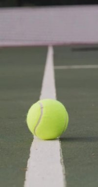 Sarı tenis topu ve tenis kortunun dikey videosu. sağlıklı ve aktif emeklilik.