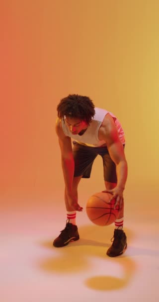 Vertical Video Biracial Male Basketball Player Ball Orange Background Sports — Stock Video