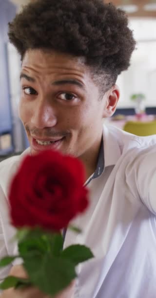 Pionowe Nagranie Uśmiechniętego Dwurasowego Mężczyzny Trzymającego Czerwoną Różę Robiącego Walentynkowe — Wideo stockowe