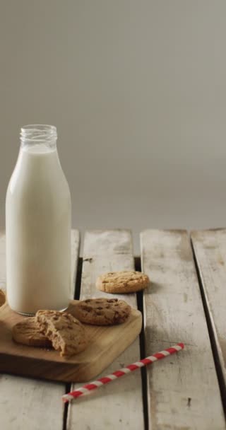 Vertikales Video Von Schokoladenkeksen Und Einer Flasche Milch Auf Schneidebrett — Stockvideo