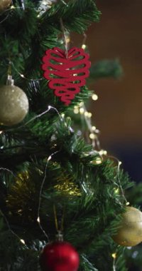 Kırmızı kalp şeklinde bir Noel süslemesinin dikey yakın çekimi. Noel konsepti.