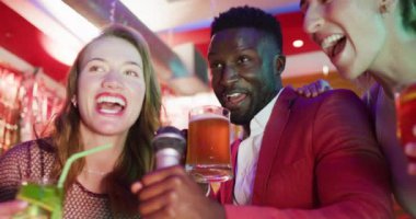 Karaoke yapan ve bir gece kulübünde içki içen çeşitli mutlu arkadaş gruplarının videoları. Arkadaşlık, eğlence, kapsayıcılık, dışarı çıkmak ve parti konsepti.