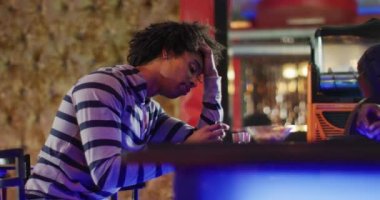 Afrikalı Amerikalı barmen ve sarhoş adamın barda içki içerken çekilmiş videosu. İçmek, dışarı çıkmak ve alkol konsepti.